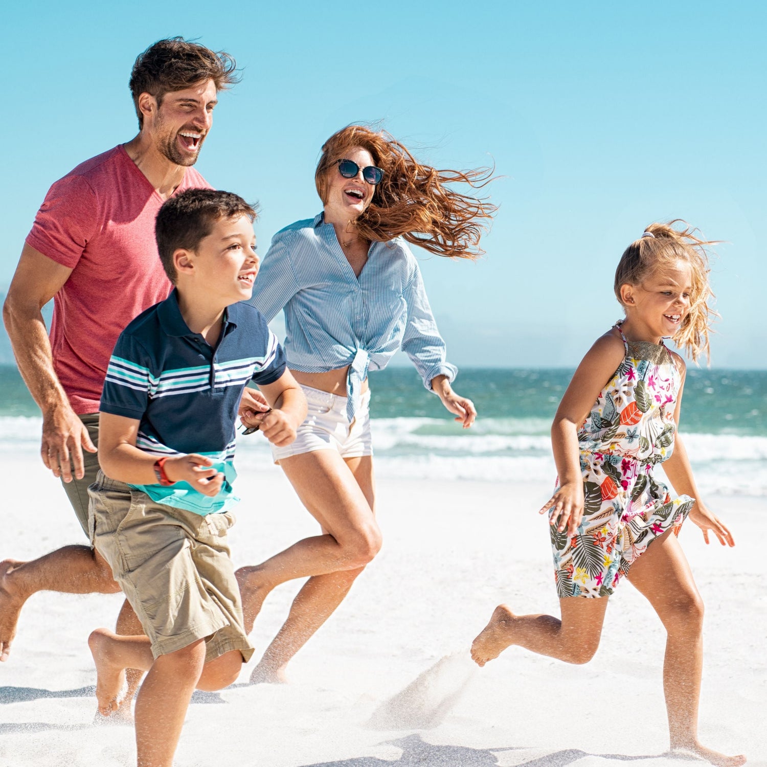 Family of four running on a sandy beach with ocean in the background from using bvoy gut health products for all round wellness